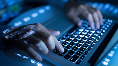 image focusing on a computer screen displaying binary code, symbolizing dark web monitoring and cybersecurity